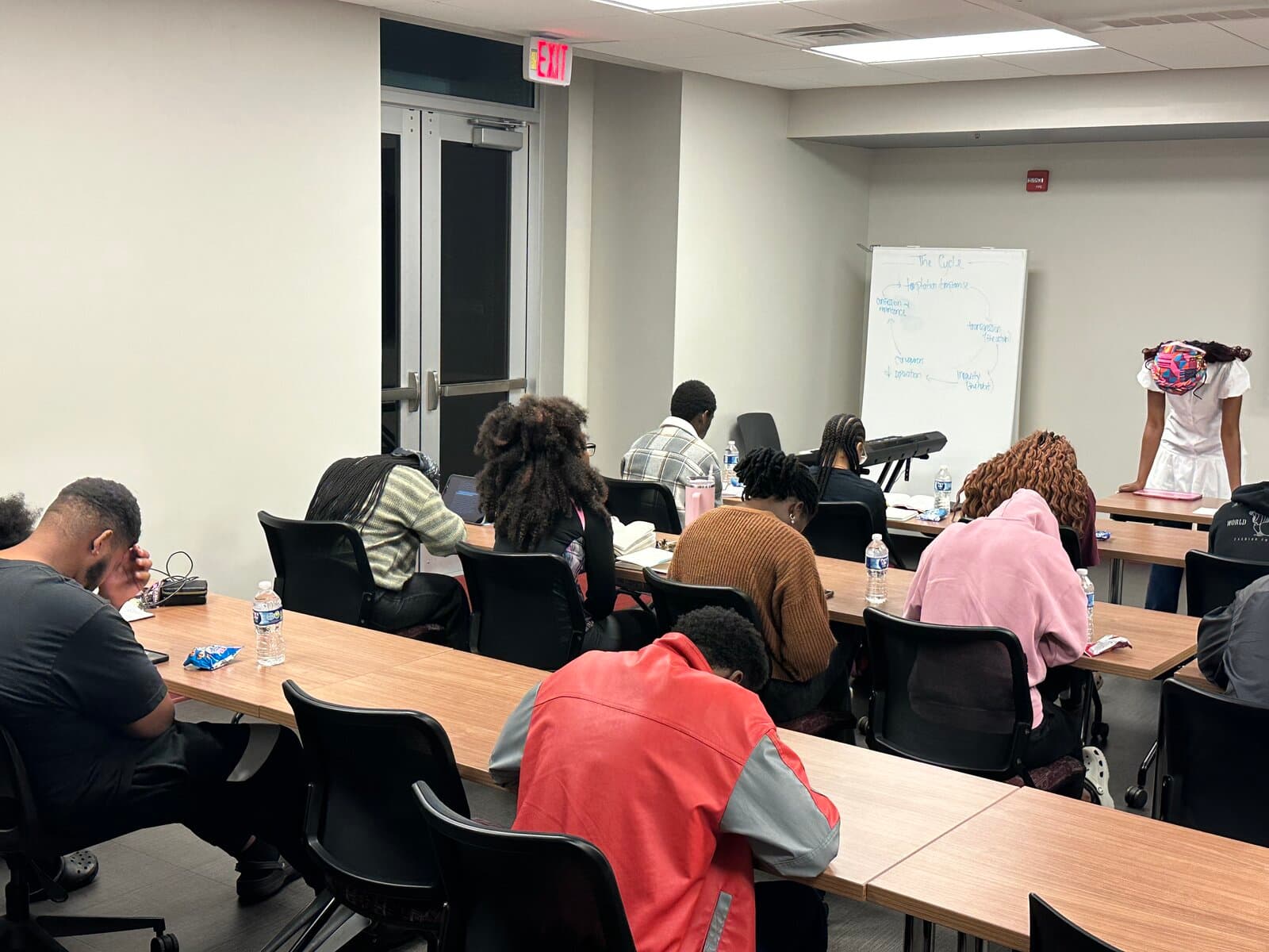 Students in prayer during Compass Campus Fellowship Bible study
